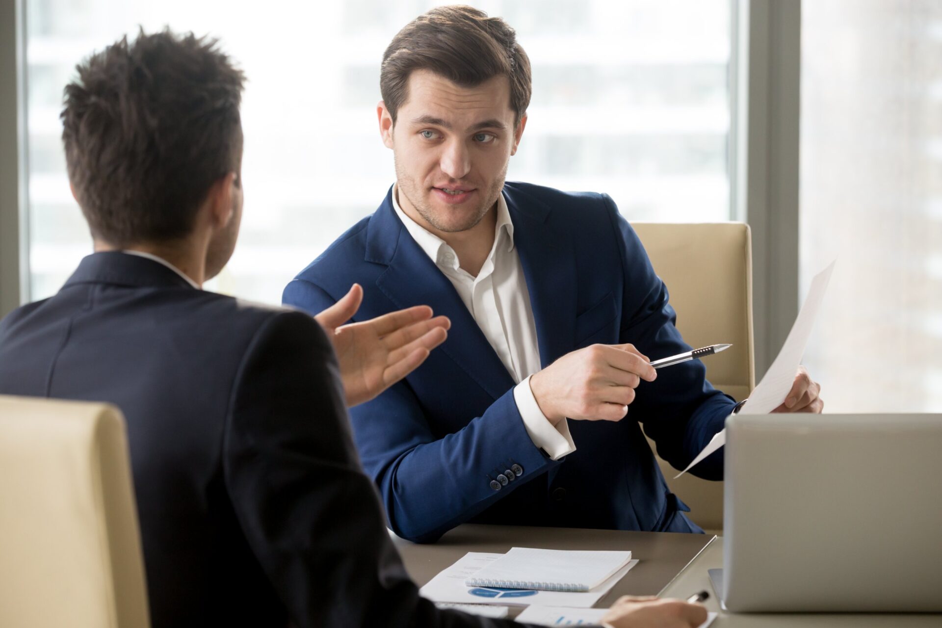 Successful businessman clarifying provisions of contract with business partner, discussing terms of agreement, explaining strategy or financial plan